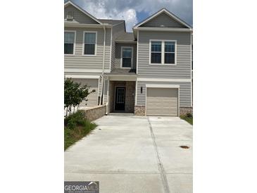 Charming townhome with attached garage, modern siding, and concrete driveway at 6116 Ripple Way # 47, South Fulton, GA 30349