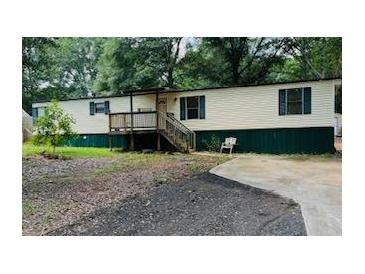 Charming single-story home with wood siding and a front porch at 215 Highland Dr, Locust Grove, GA 30248
