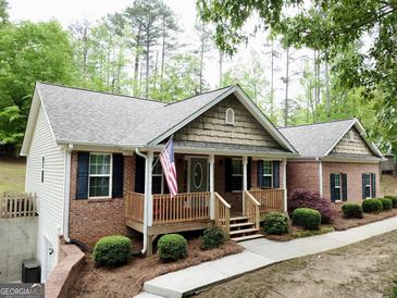 Brick ranch home with a covered porch and landscaped yard at 5460 Creek Indian Trl, Douglasville, GA 30135