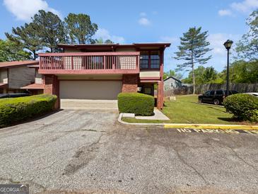 Charming townhome with a balcony, attached garage, and well-maintained landscaping in a residential community at 1084 Village Rd, Stone Mountain, GA 30088