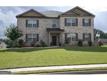 Two-story brick home with landscaped lawn and driveway at 1625 Zara Ln, Stockbridge, GA 30281