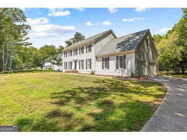 Charming two-story home featuring a large, well-manicured front lawn, attached garage, and traditional architecture at 330 N Fayette Dr, Fayetteville, GA 30214