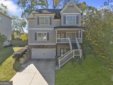 Two-story house with gray siding, attached garage, and a deck at 2632 Oakdale Nw St, Atlanta, GA 30318