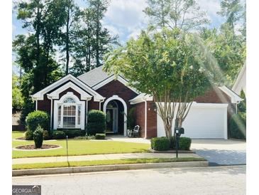 Charming brick home featuring well-manicured landscaping and a two-car garage at 121 Pinnacle Ln, Mcdonough, GA 30253