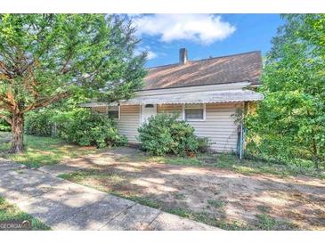 Ranch style home with awning and landscaped yard at 212 Sims St, Palmetto, GA 30268