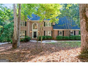 Traditional brick home with a manicured lawn and mature trees in a beautiful wooded neighborhood at 270 Emerald Lake Dr, Fayetteville, GA 30215