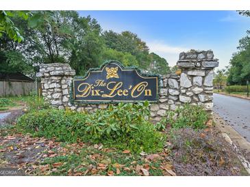 Stone community sign for The Dix-Lee'on neighborhood, surrounded by greenery and mature trees at 470 Dix Lee On Dr, Fayetteville, GA 30214