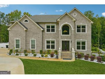 Stunning two-story brick home featuring manicured landscaping and a symmetrical facade at 3140 Jackson Creek Dr, Stockbridge, GA 30281