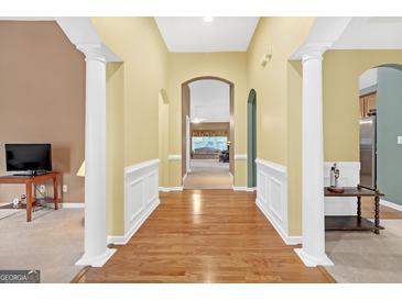 Bright foyer featuring hardwood floors, archways, and decorative white molding, leading to other rooms at 4424 Bellwood Cir, Atlanta, GA 30349