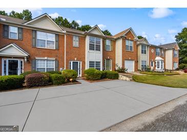Attractive brick townhomes feature well-manicured lawns and spacious driveways for convenient parking at 2783 Parkway Cv, Lithonia, GA 30058