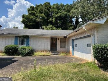 A single-story white brick home with an attached garage and a front yard at 2071 Twin Falls Rd, Decatur, GA 30032