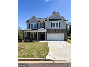 Two-story house with brick and siding, a large driveway, and a landscaped lawn at 3098 Steinbeck Way, East Point, GA 30344