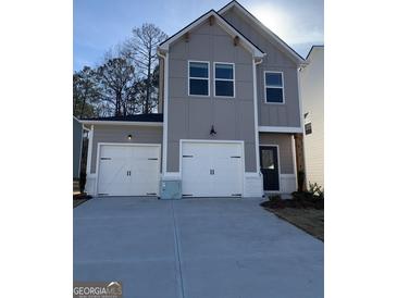 Charming two-story gray home with white trim, two-car garage, and modern black door at 209 Weldon Rd # 43, Mcdonough, GA 30253