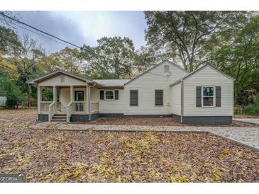 Charming single-story home featuring a welcoming front porch and neutral siding, complemented by black shutters and a metal roof at 5122 Hillcrest Nw Dr, Covington, GA 30014