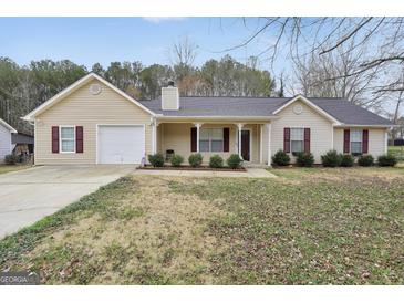 Charming home featuring manicured landscaping, a covered front porch, and a well-maintained lawn at 130 Nicki Ct, Hampton, GA 30228