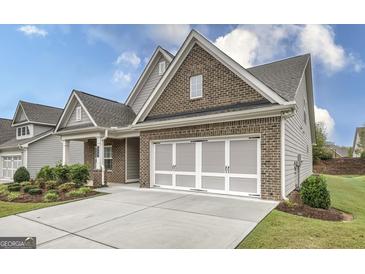 Charming single-Gathering home featuring a brick facade, two-car garage, manicured lawn and inviting landscaping at 240 Grand Oak Way, Sharpsburg, GA 30277