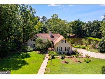 An attractive home features a manicured lawn and mature trees, offering a serene and private setting at 50 Persian Pl, Whitesburg, GA 30185