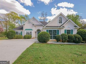 Charming single-story home with stucco exterior, landscaped yard, and well manicured green bushes at 334 Royal Crescent Way, Stockbridge, GA 30281