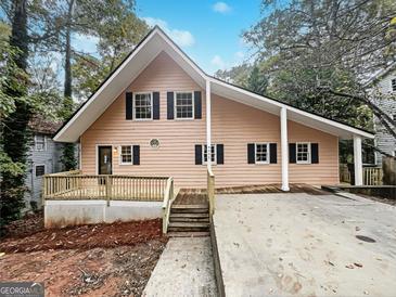 Charming A-frame home with a spacious deck, black shutters, and inviting curb appeal at 4405 Cary Dr, Snellville, GA 30039