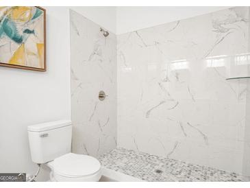 Modern bathroom featuring a tiled shower with marble-like walls and gray mosaic flooring at 2048 Chicago, Atlanta, GA 30314