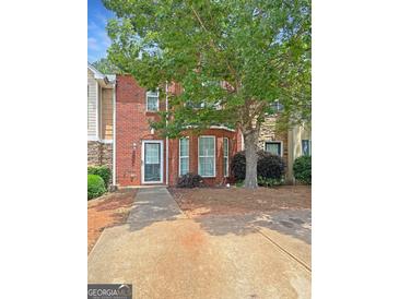 Charming brick townhome with a well-maintained front yard and a mature shade tree enhancing curb appeal at 5828 Union Walk Dr, Union City, GA 30291