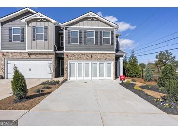 Modern townhome with brick accents, two-car garage, and a well-manicured front yard at 11521 Kimberly Way # 5, Hampton, GA 30228