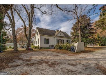 Classic two-story home featuring a spacious parking area and mature trees in a quiet neighborhood at 3810 2Nd Ave, Mansfield, GA 30055