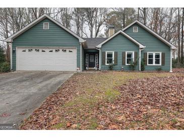 Charming single-story home featuring a two-car garage and manicured front yard with a walkway to the front door at 2744 Amber Springs Way, Buford, GA 30519