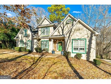 Two-story house with green accents and stonework, nestled amongst trees at 232 Terrane Rdg, Peachtree City, GA 30269