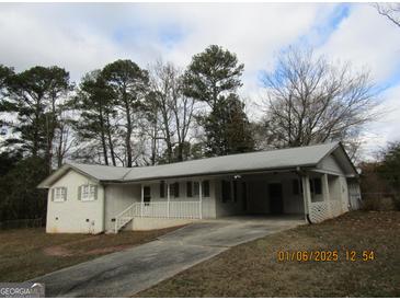 Ranch-style home with carport and mature trees at 423 Center Sw Cir, Conyers, GA 30094