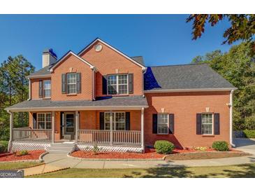 Brick two-story house with gray roof, porch, and landscaping at 2436 Green Hollow Ct, Conyers, GA 30012