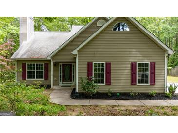 Charming single-story home with a manicured lawn, tan siding, and contrasting red shutters at 65 Riverside Way, Sharpsburg, GA 30277