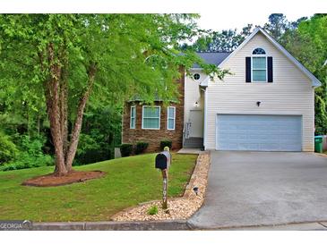 Charming two-story home featuring stone accents, a well-manicured lawn, and an attached two car garage at 4197 Arnolds Mill Opas, Douglasville, GA 30135