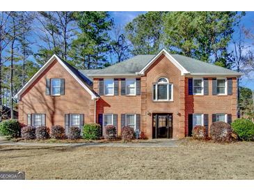 Brick two-story house with a large front yard and mature trees at 102 Morallion Hls, Peachtree City, GA 30269