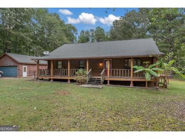 Charming log cabin home with a spacious front porch and detached garage at 184 Elm St, Covington, GA 30014