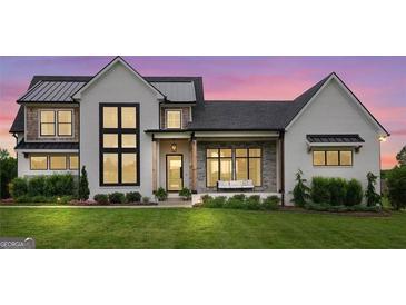 Stunning two-story farmhouse with white exterior, metal roof, and stone accents at 0 Matteo Way # 34, Fayetteville, GA 30215