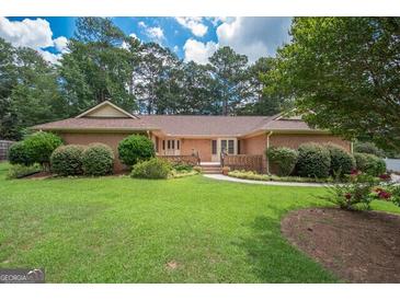 Brick ranch house with a spacious lawn and mature trees at 215 Creekside Trl, Fayetteville, GA 30214