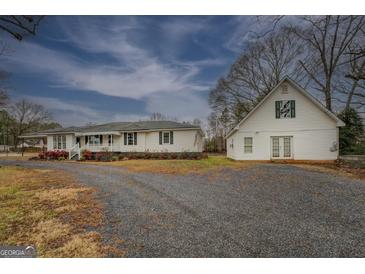 A charming white home with an adjacent building and ample parking space at 12178 Brown Bridge Rd, Covington, GA 30016