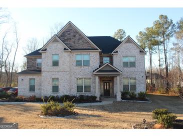 Two-story brick house with a covered entryway and landscaped lawn at 4051 Rotterdam Pass, Hampton, GA 30228