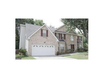 Brick house with a two-car garage and landscaped lawn at 4765 Redbranch Rd, Decatur, GA 30035