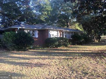 Brick ranch house with mature trees and a large yard at 1810 Highway 138 E, Stockbridge, GA 30281