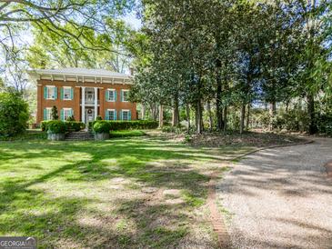 Brick two-story home with manicured lawn and long driveway at 3115 Pennington Sw St, Covington, GA 30014