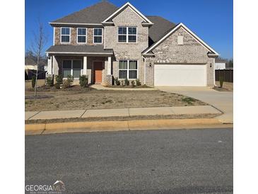 Two story house with brick facade and a two car garage at 212 Himalaya Way, Mcdonough, GA 30253