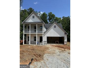 Two-story home featuring a two-car garage and a charming porch at 115 Yancey Rd, Covington, GA 30014