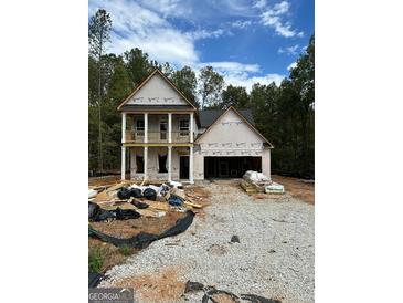 Two-story house under construction, features a front porch and attached garage at 115 Yancey Rd, Covington, GA 30014