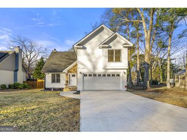 Charming two-story house with a white exterior, two-car garage, and manicured lawn at 2473 Baker Nw Rd, Atlanta, GA 30318