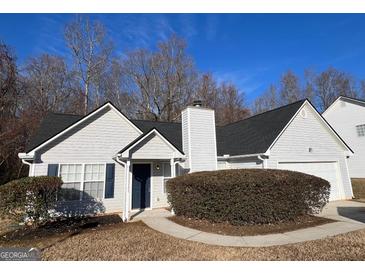 White house with dark grey roof,attached garage, and manicured shrubbery at 190 Wynfield Dr, Covington, GA 30016