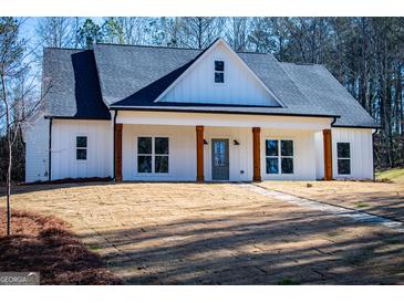 White farmhouse exterior with a front porch and landscaping at 16 Edgewater Dr, Temple, GA 30179