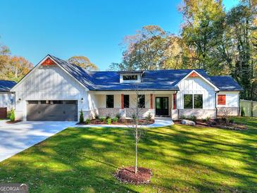 Craftsman style home with white siding, gray roof, and a landscaped lawn at 1947 Clark Dr, Tucker, GA 30084