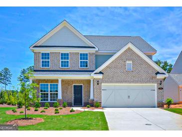 Two-story brick home with a large front yard and attached two-car garage at 303 Roundwood Way, Peachtree City, GA 30269